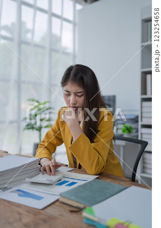 Young businesswoman analyzing reports and charts in a modern office environment while working on important projects 123254658