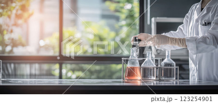 Laboratory technician conducting experiments with glassware and liquids 123254901