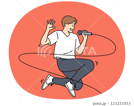 Jumping male singer with microphone enjoys performing energetic songs at karaoke party Jumping male singer with microphone enjoys performing energetic songs at karaoke party 123255853