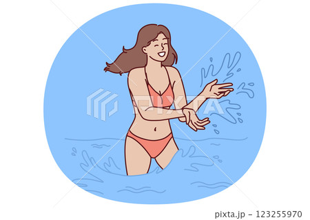 Woman in bikini swims in sea and splashes with water enjoying summer travel or trip to aquapark 123255970