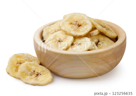 Dried banana chips in a wooden plate and pieces on a white background. Isolated 123256635