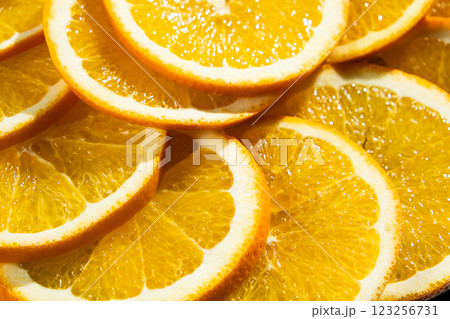 Orange background, ripe oranges cut into slices close-up. 123256731