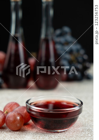 Red wine vinegar in glass vinegar bowls among grapes Red wine vinegar in glass vinegar bowls among grapes 123256753