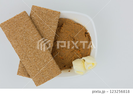 Close-up of a white plate with liver pate and slices of butter, bread on top on a white background in the center. The concept of snacks, healthy food, diet. High quality photo Close-up of a white plate with liver pate and slices of butter, bread on top on a white background in the center. The concept of snacks, healthy food, diet. High quality photo 123256818