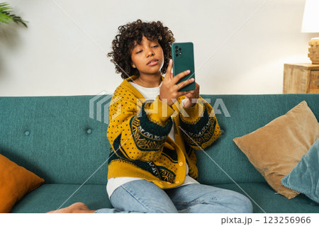 African American girl holding smartphone having video chat. Female blogger chatting with best friends in social network. Young woman having virtual meeting online chat video call at home African American girl holding smartphone having video chat. Female blogger chatting with best friends in social network. Young woman having virtual meeting online chat video call at home 123256966