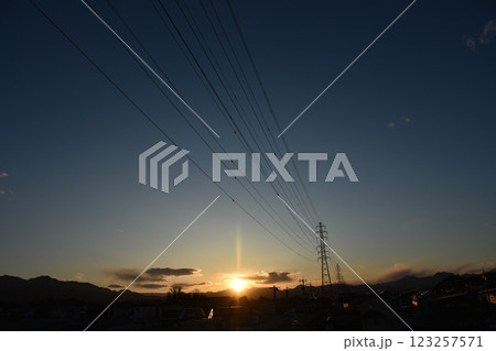 夕暮れ時の山の向こうに見える送電線と鉄塔 123257571