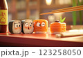 A colorful display of cartoon sushi pieces on a wooden table. The sushi features cute, expressive faces and is accompanied by chopsticks and a bottle of soy sauce. Bright colors dominate the scene. 123258050