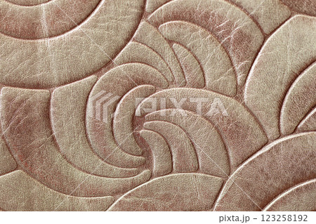 Embossed leather texture with an elegant abstract pattern of curved shapes. Luxury design, fashion, upholstery applications. High-end craftsmanship, decorative leather accessory concept Embossed leather texture with an elegant abstract pattern of curved shapes. Luxury design, fashion, upholstery applications. High-end craftsmanship, decorative leather accessory concept 123258192