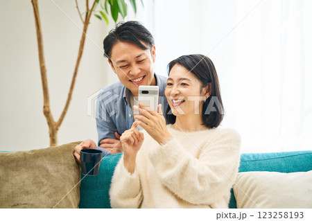 スマートフォンを見る夫婦 スマートフォンを見る夫婦 123258193