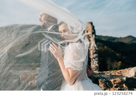 Portrait of beautiful bride and groom under the veil. Portrait of beautiful bride and groom under the veil. 123258274