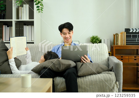 Relaxed young couple lounging on a cozy couch during leisure weekend time 123259335