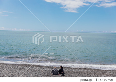 Man And Woman Sitting On Beach And Looking At Sea 123259796