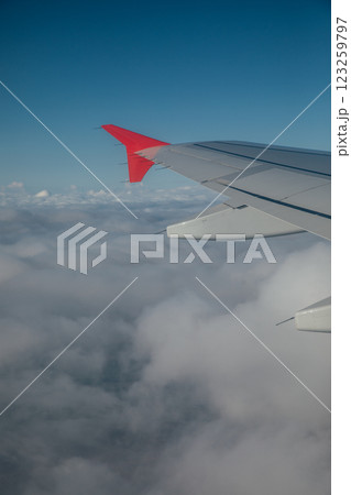 Airplane wings against blue sky background with clouds in flight 123259797