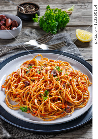 vegan whole grain pasta alla puttanesca on a plate 123260114