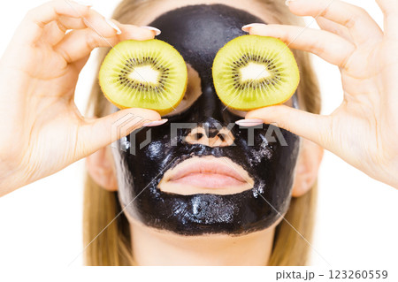 Girl black mask on face holds kiwi fruit 123260559