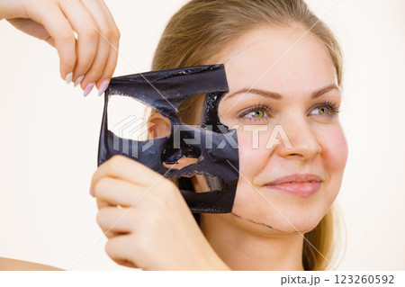 Girl removes black mask from face Girl removes black mask from face 123260592