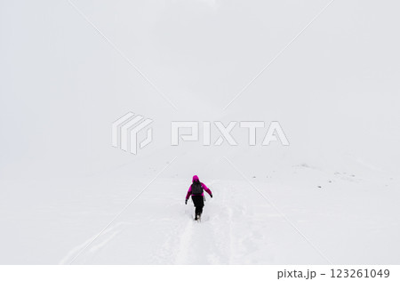 Lone hiker in snowy whiteout 123261049