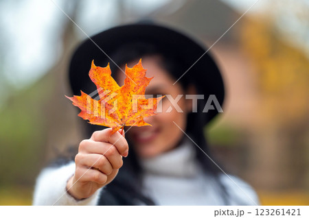 Portrait of a beautiful young woman in the autumn park with maple leaf Portrait of a beautiful young woman in the autumn park with maple leaf 123261421