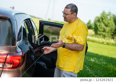 worried and emotional man at open car fuel tank, fuel price rise concept worried and emotional man at open car fuel tank, fuel price rise concept 123261921