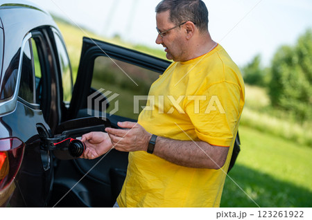 worried and emotional man at open car fuel tank, fuel price rise concept worried and emotional man at open car fuel tank, fuel price rise concept 123261922