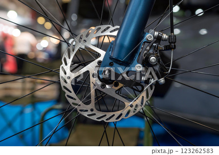 Closeup of a metal brake disc on the front wheel of a mountain bike. Closeup of a metal brake disc on the front wheel of a mountain bike. 123262583