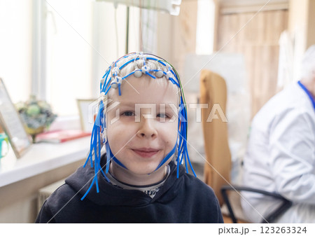 A boy's brain is examined on an EEG machine. Electroencephalogram is performed in a hospital laboratory to detect neurological diseases. Encephalogram for children 123263324