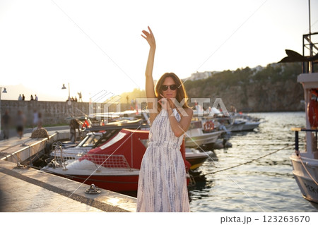 Happy woman enjoying golden sunset at the harbor  123263670