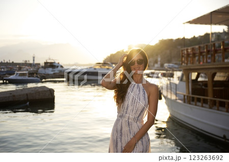 Stylish woman posing at sunset by the marina  123263692