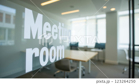 Contemporary meeting room in a modern office with glass walls, large table, and various chairs. Bright area for team collaboration, business discussions, professional gatherings, open workspace 123264250