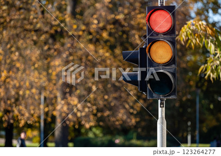 Red and orange traffic light in semaphore closeup. Bright colored autumn background. 123264277