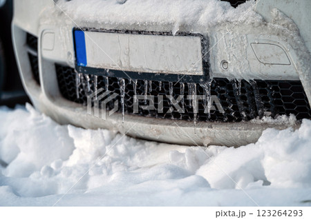 Car number in icicles in winter. Frozen number plate car bumper with icicles. 123264293
