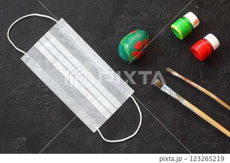 Medical protective face mask and colorful easter eggs isolated on black background. Concept of Easter holiday during the global pandemic coronavirus. Flat lay, top view, copy space. 123265219