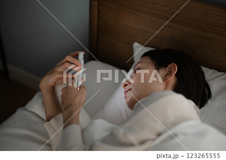 ベッドでスマホを使う女性 ベッドでスマホを使う女性 123265555