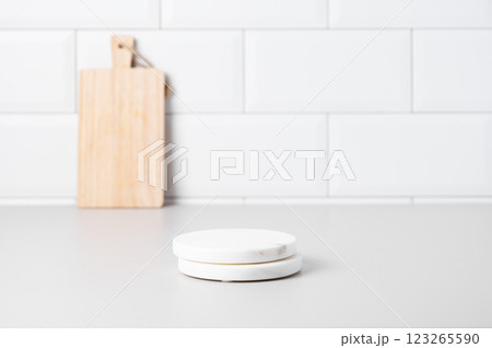 Kitchen countertop with marble stands and wooden board on white brick background. Kitchen countertop with marble stands and wooden board on white brick background. 123265590