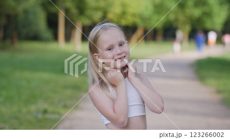 A young girl delights in the stunning beauty of nature, showcasing her innocent joy in a lovely park setting 123266002