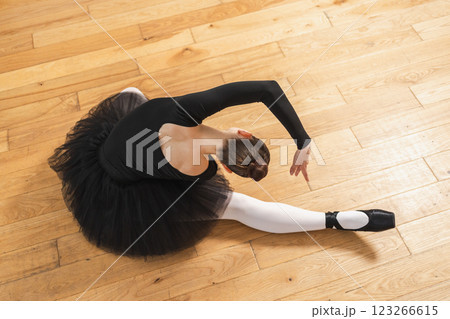Young ballerina in tutu skirt stretching practicing ballet positions dancing on floor in dance class. Young classical dancer woman in dance studio. Ballet class training Ballet school concept Young ballerina in tutu skirt stretching practicing ballet positions dancing on floor in dance class. Young classical dancer woman in dance studio. Ballet class training Ballet school concept 123266615
