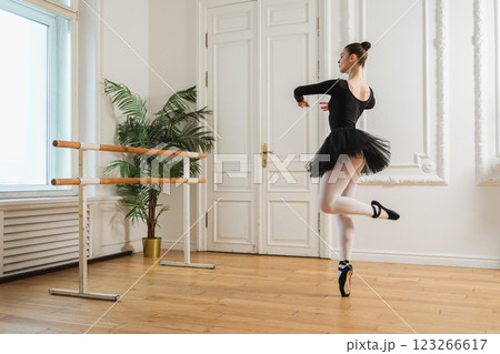Young ballerina in tutu skirt dancing practicing ballet positions in dance class. Young classical dancer woman in dance studio. Ballet class training. Performer girl rehearsing dance in ballet school Young ballerina in tutu skirt dancing practicing ballet positions in dance class. Young classical dancer woman in dance studio. Ballet class training. Performer girl rehearsing dance in ballet school 123266617