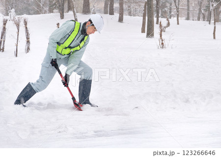 雪かきをする作業服の男性 123266646