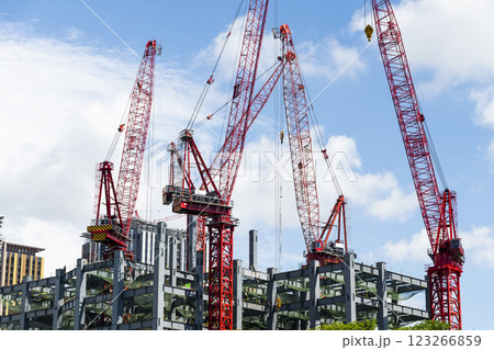 Low-angle view of cranes and steel structures of building construction with a blue sky background in Taiwan. Low-angle view of cranes and steel structures of building construction with a blue sky background in Taiwan. 123266859