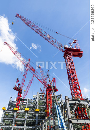 Low-angle view of cranes and steel structures of building construction with a blue sky background in Taiwan. 123266860