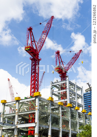 Low-angle view of cranes and steel structures of building construction with a blue sky background in Taiwan. Low-angle view of cranes and steel structures of building construction with a blue sky background in Taiwan. 123266862