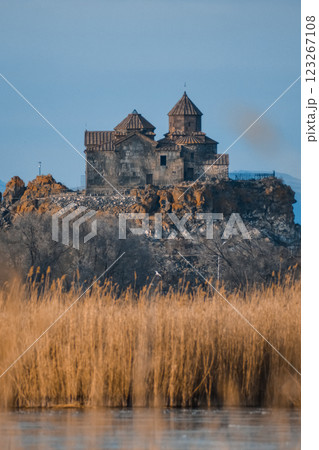 Monastery on the lake shore. Churches on the river bank. Winter landscape with church and lake. Monastery in nature. Frozen lake and rocky mountains	 123267108
