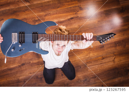 Proud man raising his electric guitar Proud man raising his electric guitar 123267595