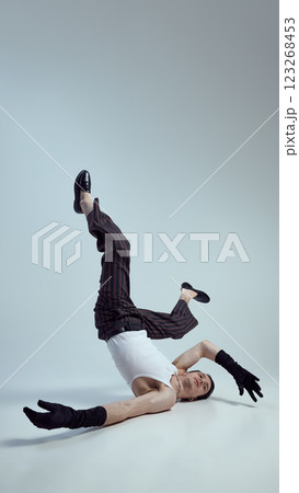 Young man dressed high-fashion attitude, embodying modern elegance with bold styling, expressively posing against gradient background. Young man dressed high-fashion attitude, embodying modern elegance with bold styling, expressively posing against gradient background. 123268453