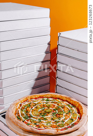 Delicious pizza surrounded by pizza boxes against a vibrant backdrop 123268673