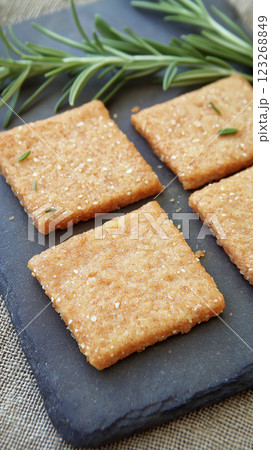 Crispy bulgur crackers with smoky paprika and rosemary on slate board. Rustic handmade appeal with soft natural lighting. 123268849