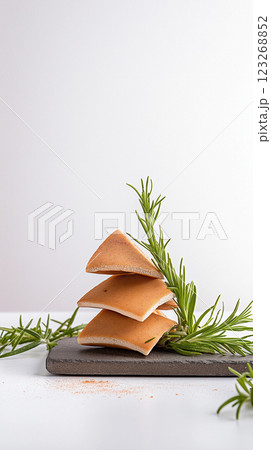 Crispy bulgur crackers with smoky paprika and rosemary on slate board. Rustic handmade appeal, soft natural light, and earthy tones. 123268852