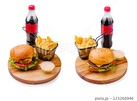 Delicious burgers with fries and soda served on wooden boards Delicious burgers with fries and soda served on wooden boards 123268946