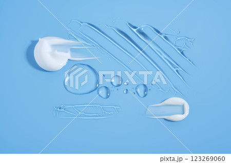 Drops and smears of cosmetic products on a blue background. 123269060