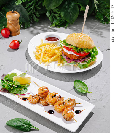 Delicious burger and shrimp dish served with fries and salad 123269117